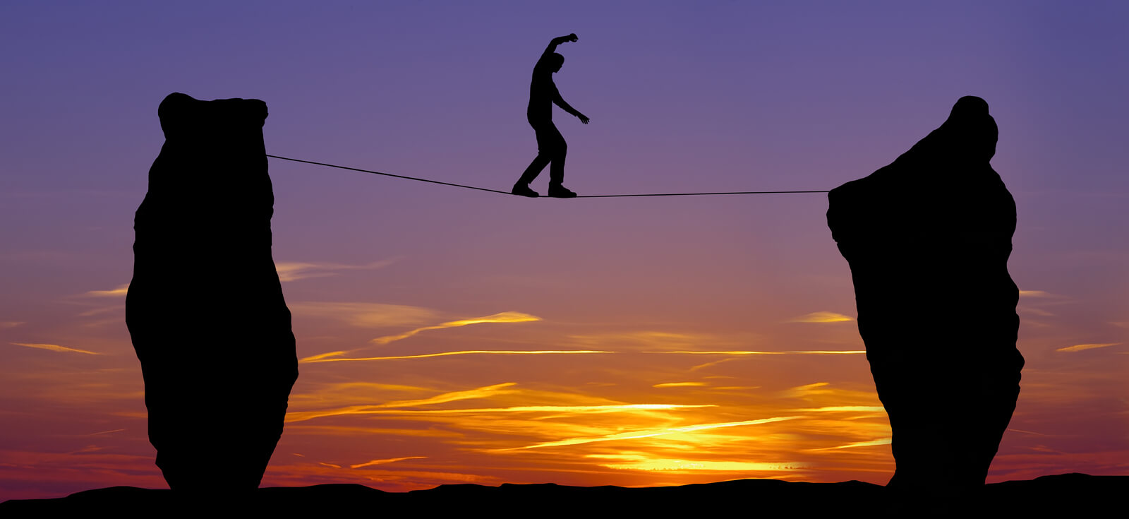 Silhouette Of A Man Walking On The Tightrope